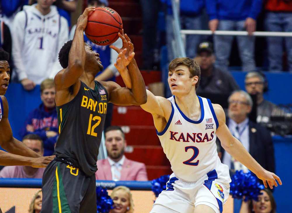 Kansas Guard Christian Braun fouls Baylor Guard Jared Butler