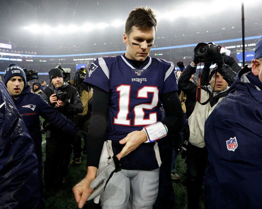 Tom Brady of the New England Patriots walks off the field following a playoff loss.