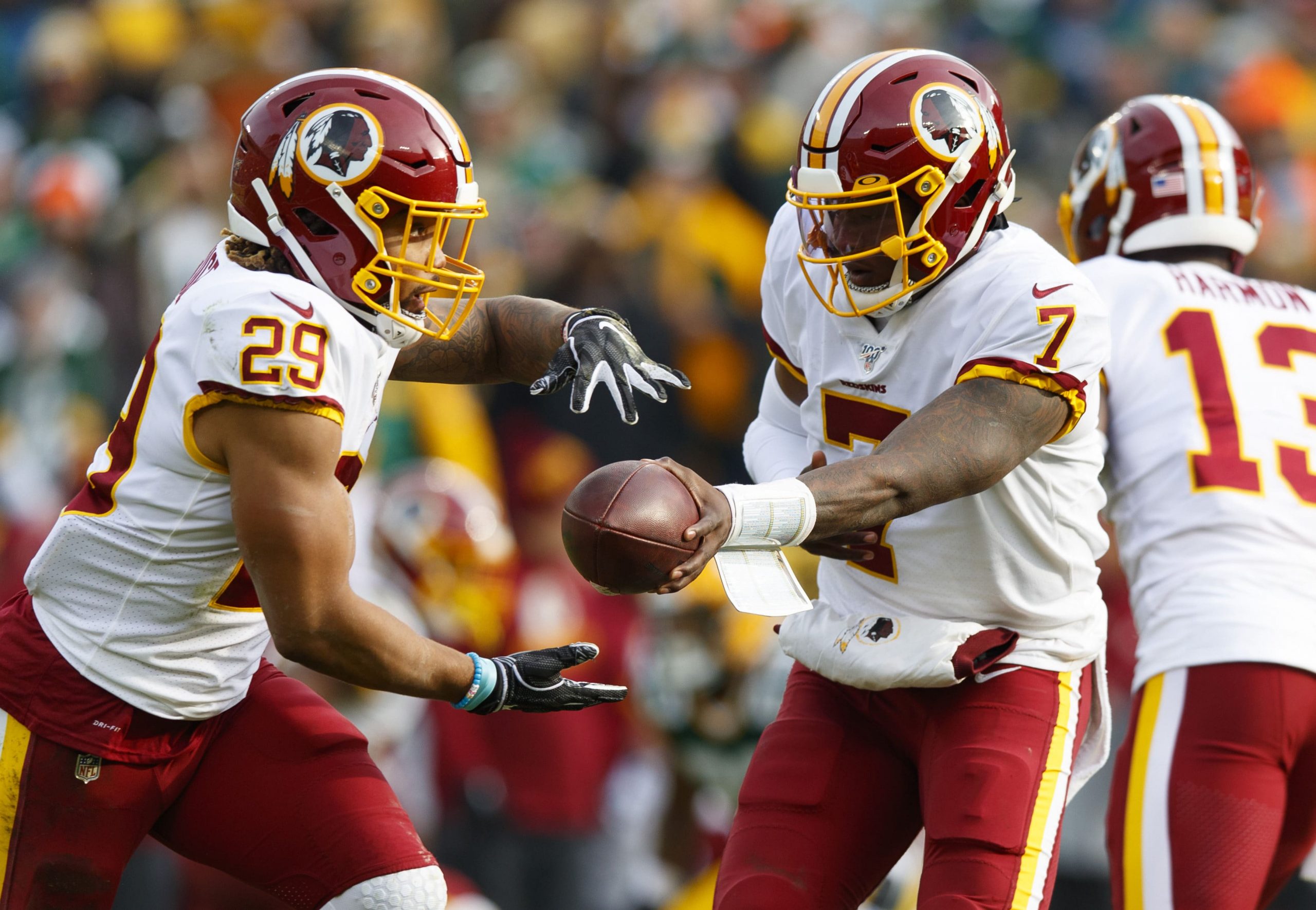 Dwayne Haskins hands the ball off to Washington teammate Derrius Guice.