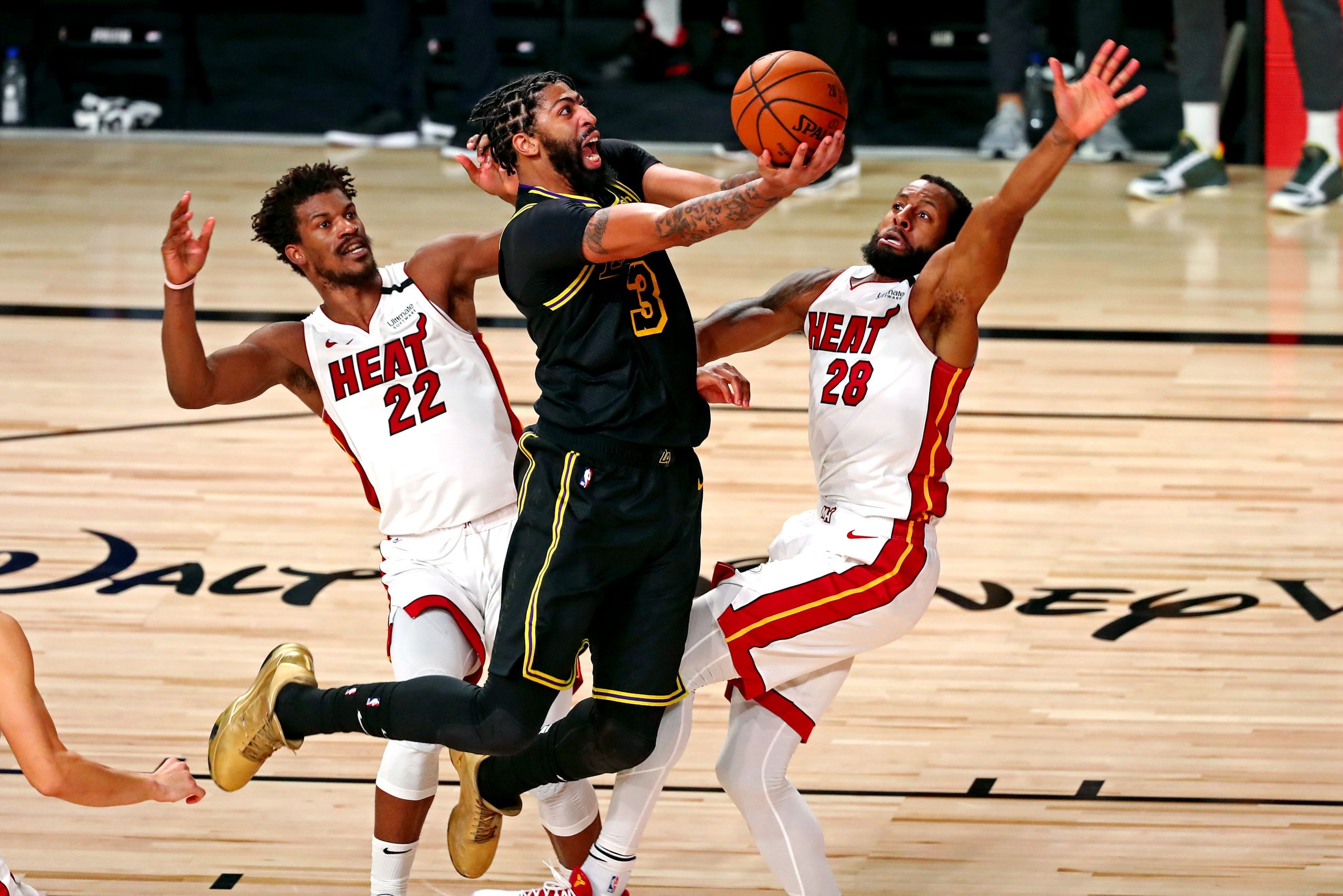 Los Angeles Lakers forward Anthony Davis shoots the ball against Miami Heat forward Jimmy Butler and guard Andre Iguodala during the fourth quarter in Game 5 of the 2020 NBA Finals.