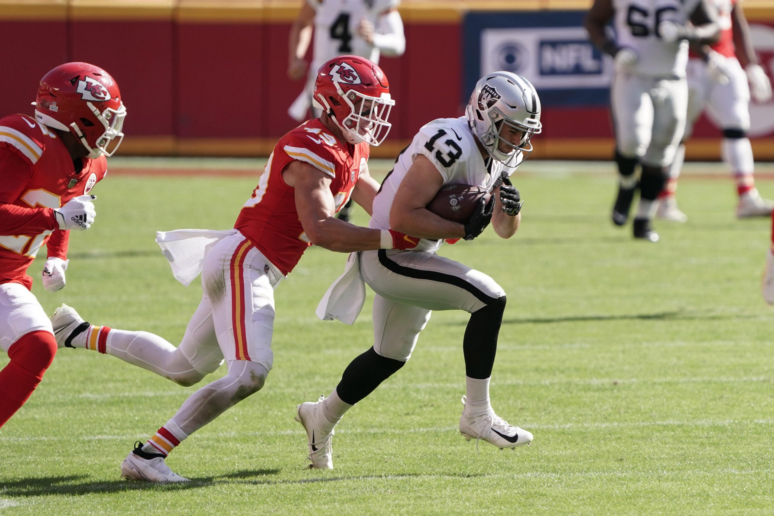 Las Vegas Raiders wide receiver Hunter Renfrow (13) is defended by Kansas City Chiefs free safety Juan Thornhill (22) and free safety Daniel Sorensen (49) on a 42-yard reception in the fourth quarter at Arrowhead Stadium.