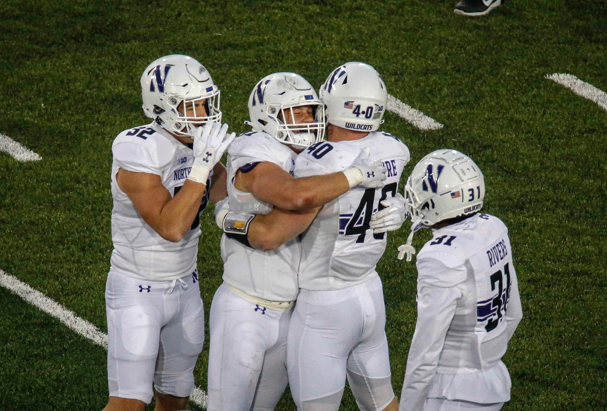 Members of the Northwestern defense celebrate after pulling down an interception late in the game against Iowa to seal the Wildcats' 21-20 win at Kinnick Stadium in Iowa City on Saturday, Oct. 31, 2020.