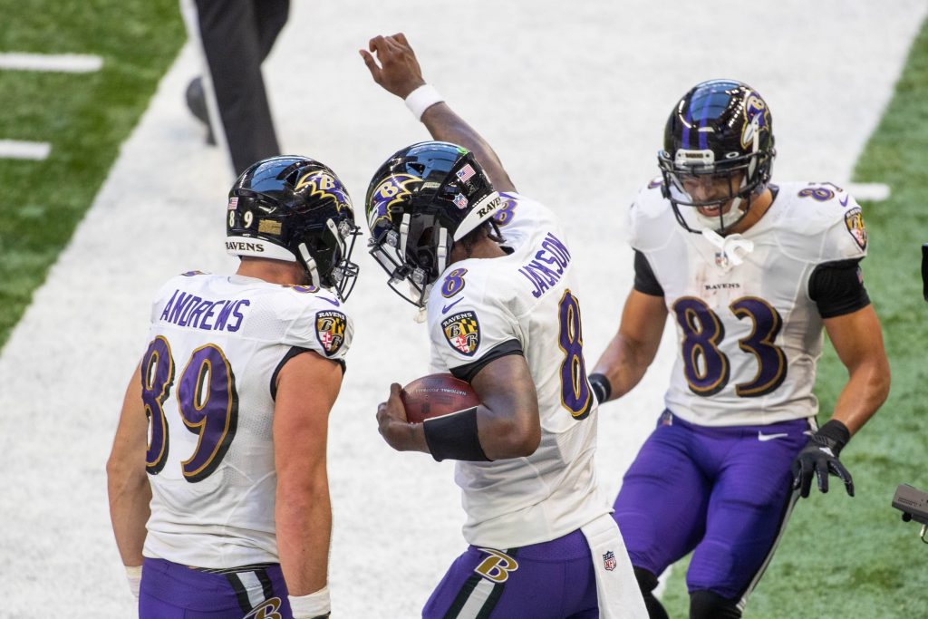Quarterback Baltimore Ravens Lamar Jackson merayakan dengan rekan setimnya setelah mencetak gol
