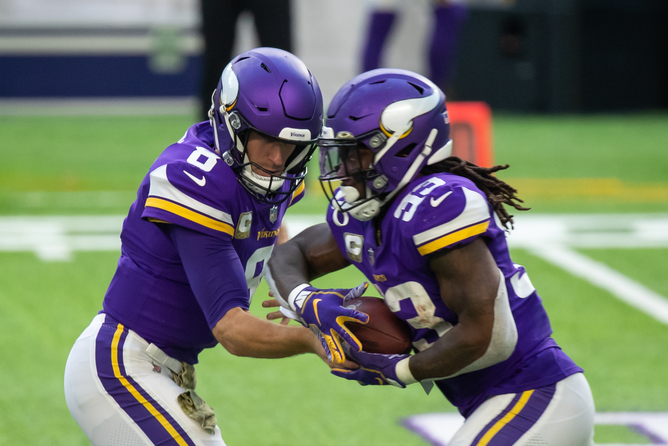 Minnesota Vikings quarterback Kirk Cousins (8) hands the ball off to running back Dalvin Cook (33) against the Detroit Lions in the third quarter at U.S. Bank Stadium.