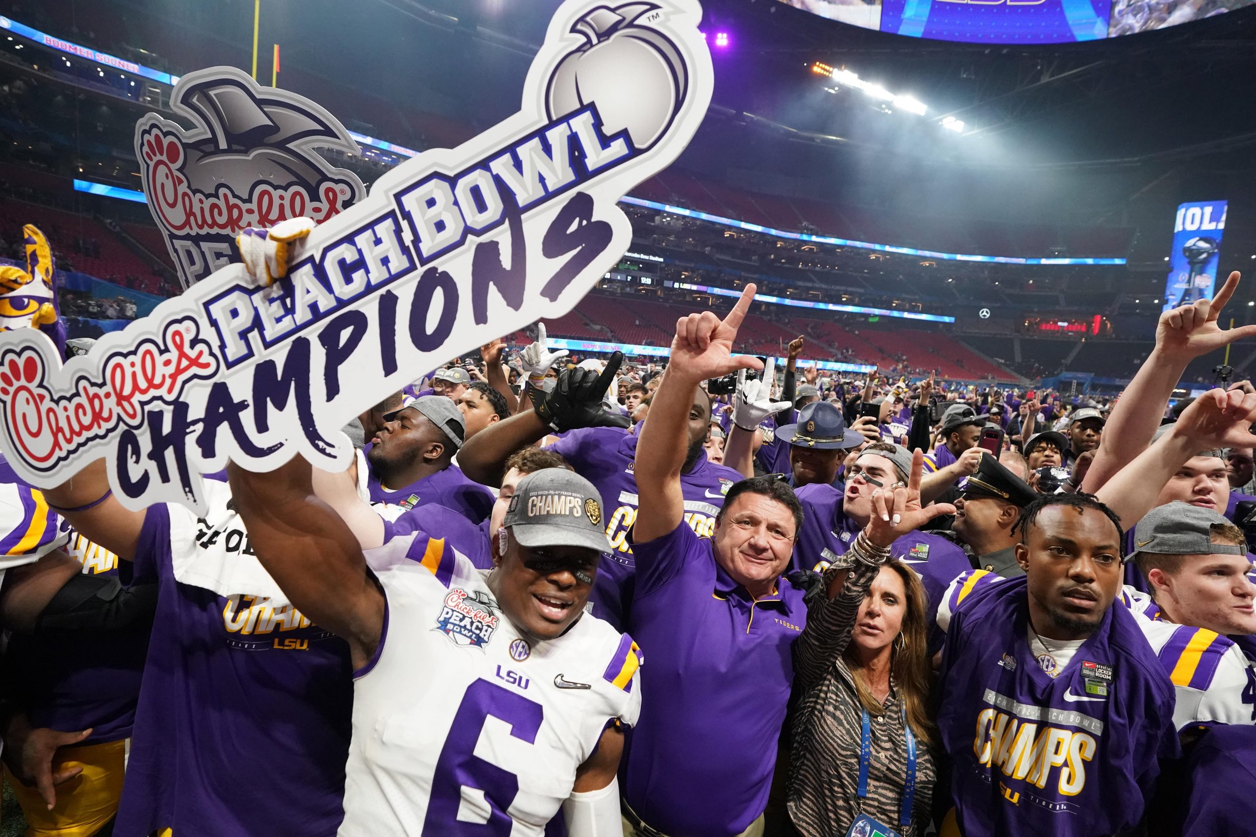LSU Tigers head coach Ed Orgeron celebrates with his players and his wife Kelly after defeating the Oklahoma Sooners in the 2019 Peach Bowl college football playoff semifinal game at Mercedes-Benz Stadium in Atlanta, Georgia.