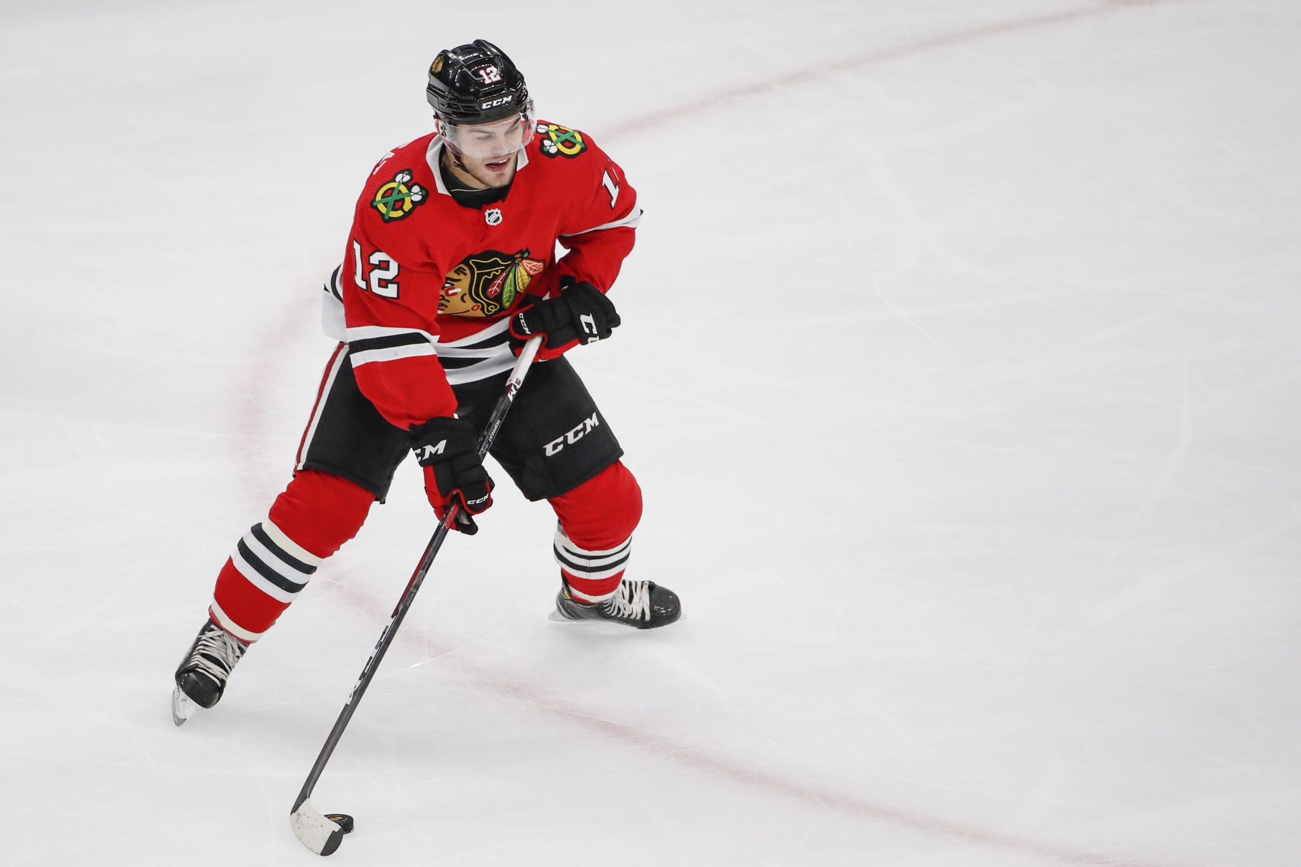 Mar 5, 2020; Chicago, Illinois, USA; Chicago Blackhawks left wing Alex DeBrincat (12) shoots and scores against the Edmonton Oilers during the second period at United Center.