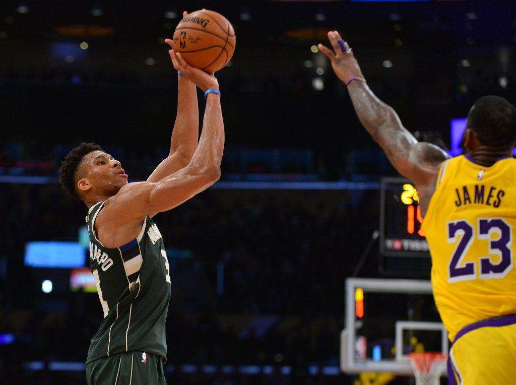 Milwaukee Bucks forward Giannis Antetokounmpo shoots over Los Angeles Lakers forward LeBron James