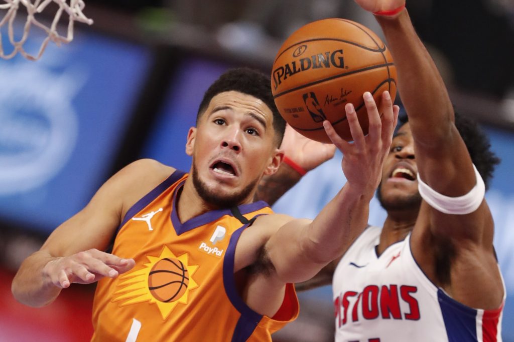 Phoenix Suns guard Devin Booker (1) goes up for a shot against Detroit Pistons guard Saddiq Bey (41) during overtime at Little Caesars Arena.