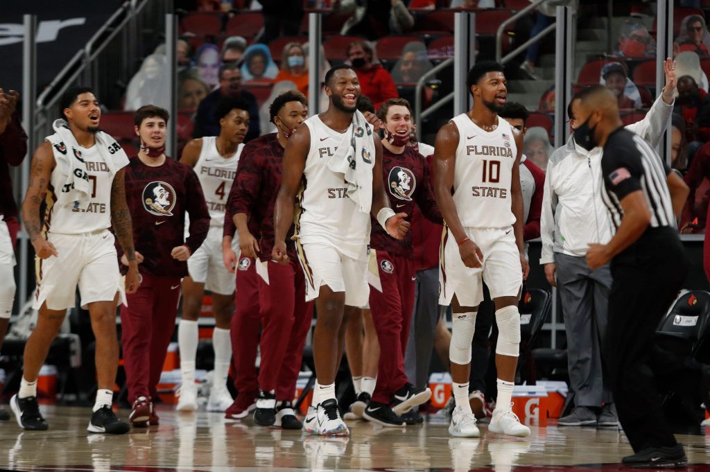 Florida State seminoles basketball players celebrate a win over the Louisville Cardinals