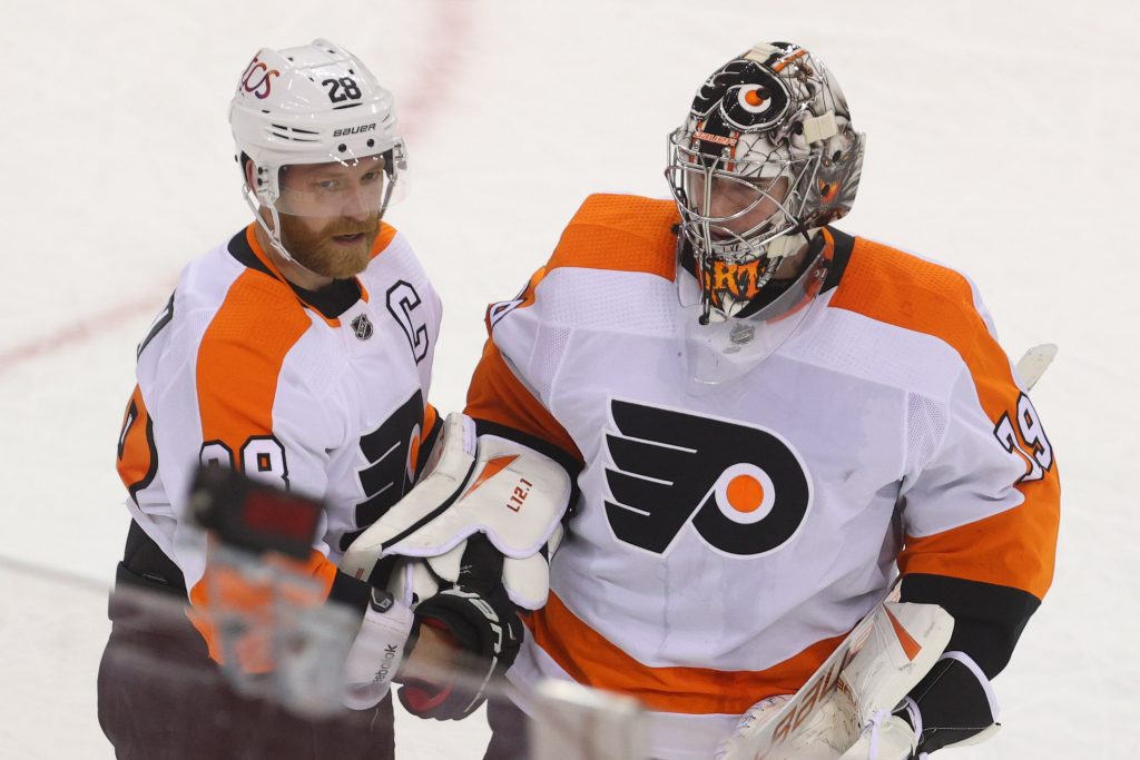 Philadelphia Flyers center Claude Giroux and goaltender Carter Hart (79) celebrate the Flyers' 3-1 win over the New Jersey Devils