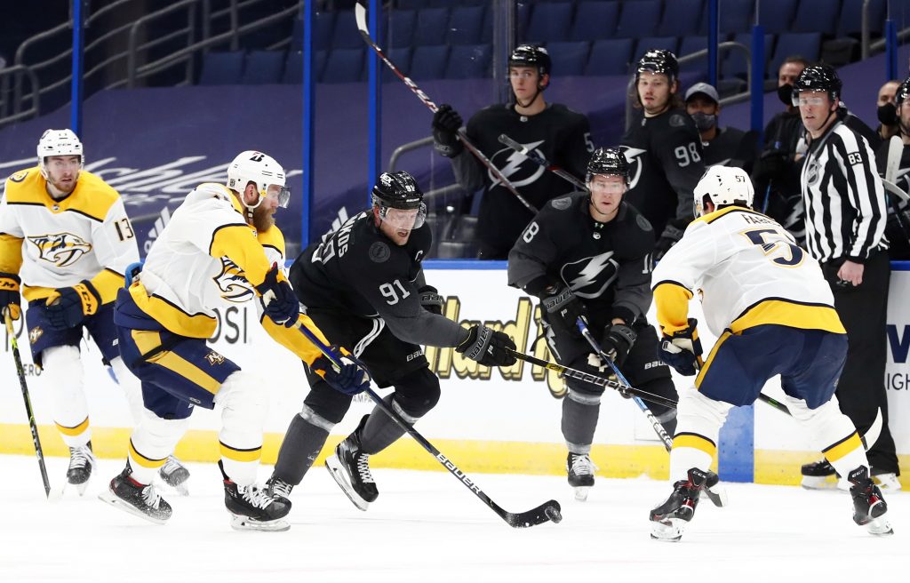 Nashville Predators defenseman Mattias Ekholm (14) and Tampa Bay Lightning center Steven Stamkos (91) skate to control the puck during the third period at Amalie Arena.