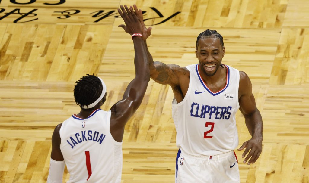 LA Clippers guard Reggie Jackson (1) and forward Kawhi Leonard (2) celebrate a basket to end the third quarter against the Orlando Magic at Amway Center.