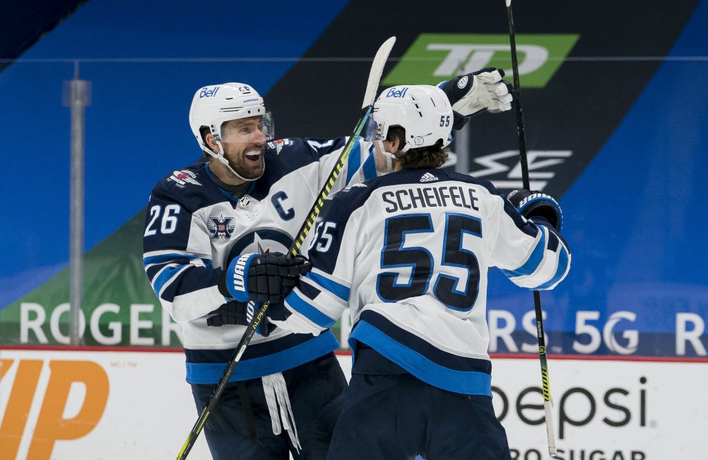 Feb 21, 2021; Vancouver, British Columbia, CAN; Winnipeg Jets forward Blake Wheeler (26) and forward Mark Scheifele (55) celebrate ScheifeleÕs goal against the Vancouver Canucks in the third period at Rogers Arena. Jets won 4-3 in Overtime.