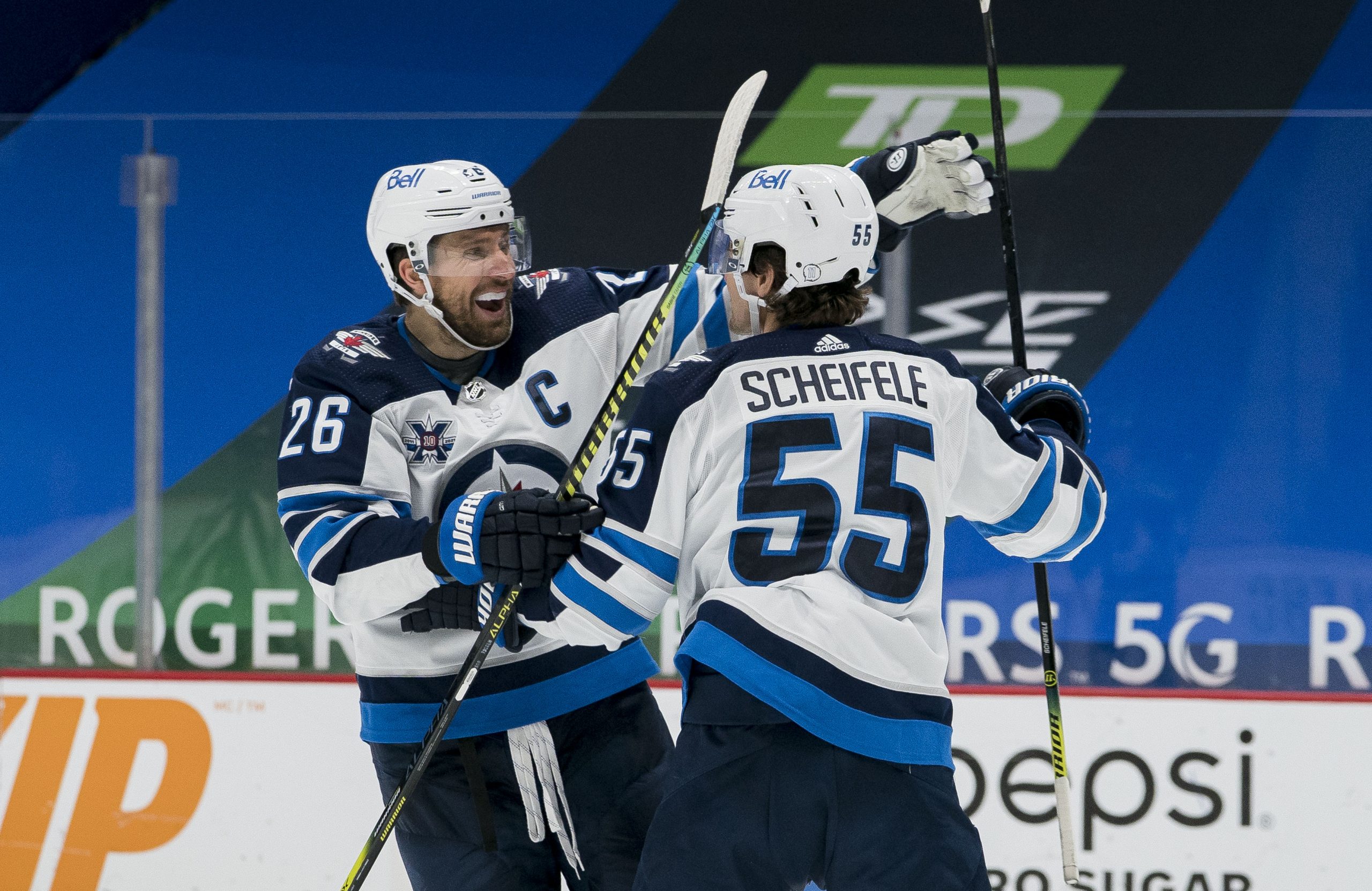 Feb 21, 2021; Vancouver, British Columbia, CAN; Winnipeg Jets forward Blake Wheeler (26) and forward Mark Scheifele (55) celebrate ScheifeleÕs goal against the Vancouver Canucks in the third period at Rogers Arena. Jets won 4-3 in Overtime.