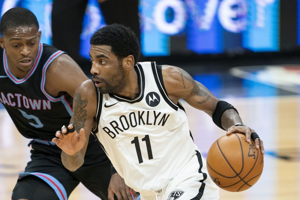 February 15, 2021; Sacramento, California, USA; Brooklyn Nets guard Kyrie Irving (11) dribbles the basketball against Sacramento Kings guard De'Aaron Fox (5) during the first quarter at Golden 1 Center