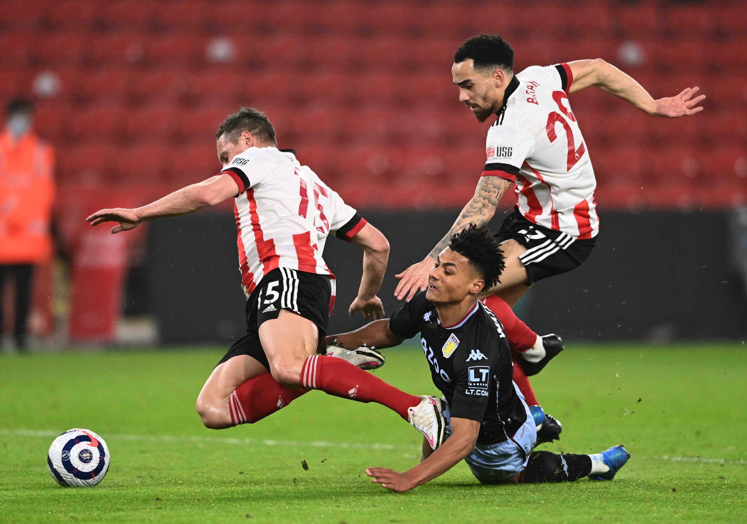 Aston Villa's Ollie Watkins (floor) battles for the ball with Sheffield United's Kean Bryan (right) and Phil Jagielka during the Premier League match at Bramall Lane, Sheffield.