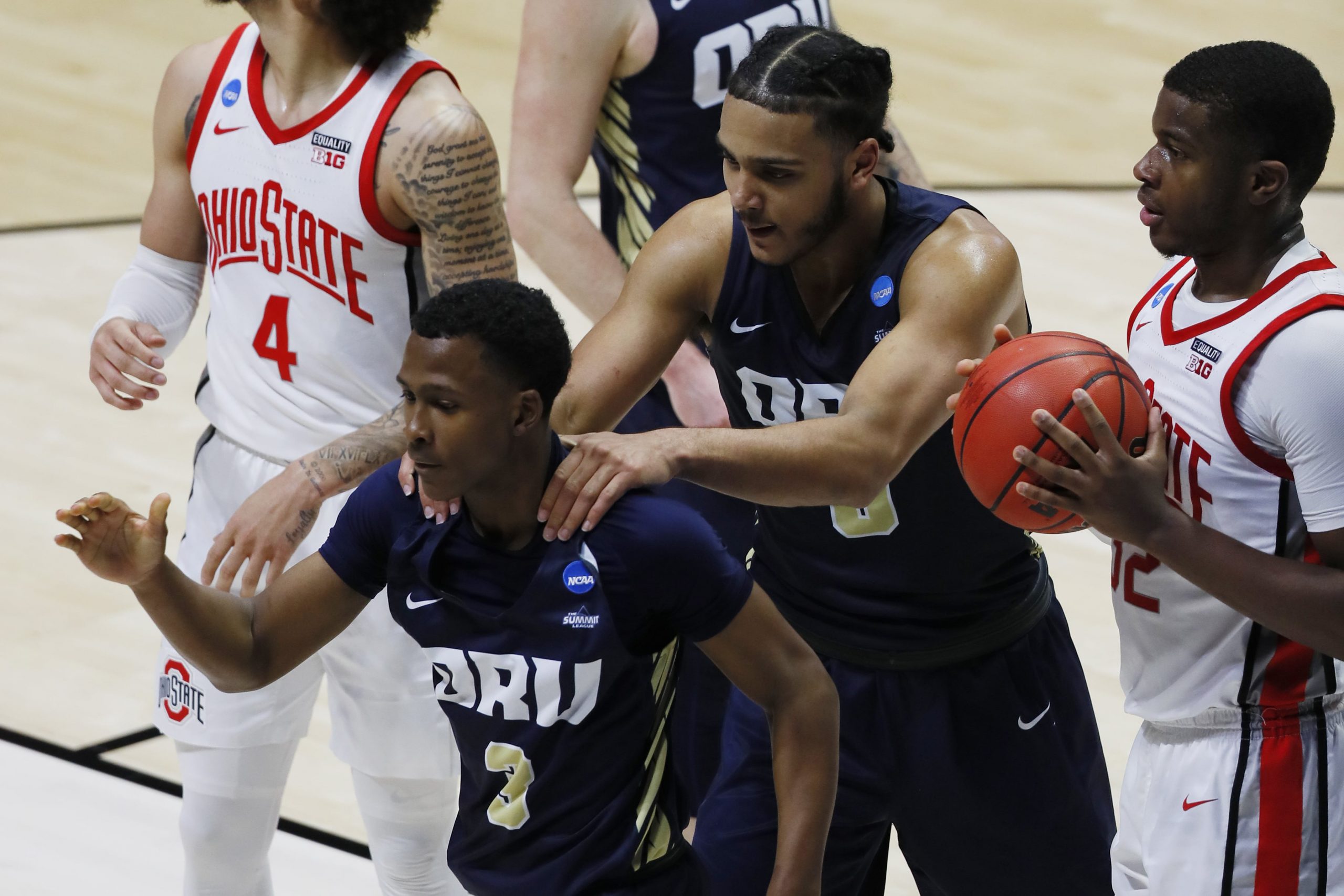 Oral Roberts Golden Eagles guard Max Abmas (3) celebrates with forward Kevin Obanor (middle) after gaining possession on a jump ball against Ohio State Buckeyes forward E.J. Liddell (right) during the second half in the first round of the 2021 NCAA Tournament at Mackey Arena