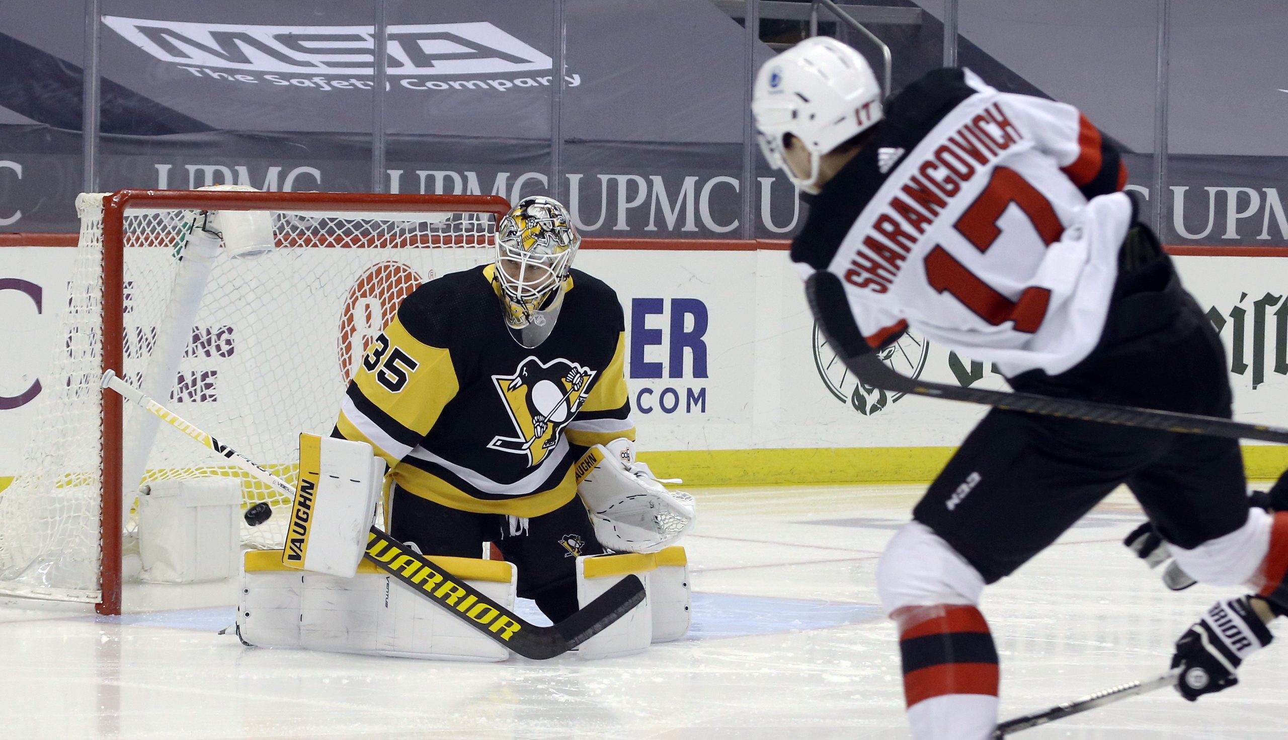 Mar 21, 2021; Pittsburgh, Pennsylvania, USA; Pittsburgh Penguins goaltender Tristan Jarry (35) makes a save against New Jersey Devils center Yegor Sharangovich (17) during the first period at PPG Paints Arena. New Jersey won 2-1 in overtime.