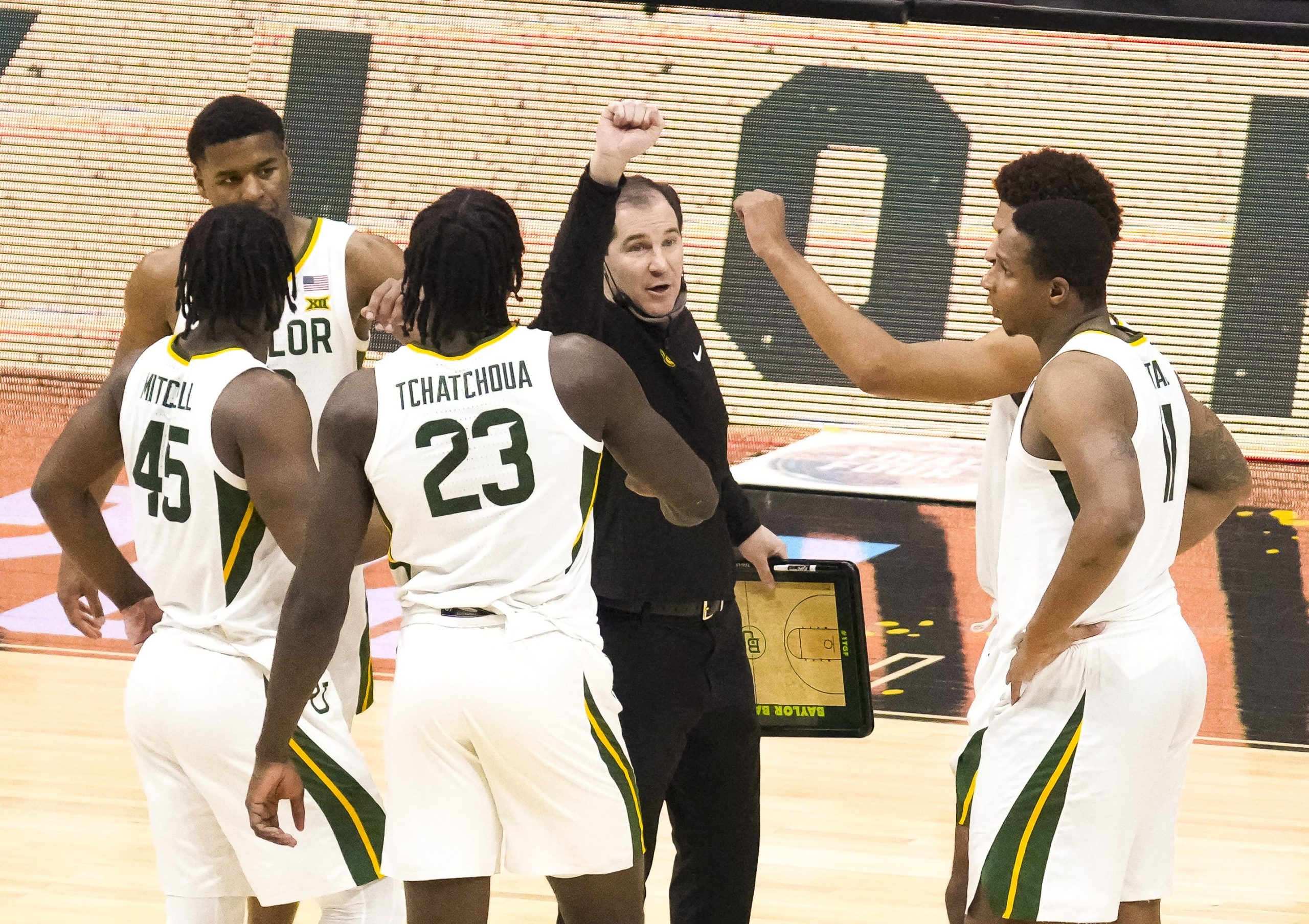 Baylor Bears head coach Scott Drew talks with guard Jared Butler (12) and guard Davion Mitchell (45) and forward Jonathan Tchamwa Tchatchoua (23) and guard Mark Vital (11) during the first half against the Houston Cougars in the national semifinals of the Final Four of the 2021 NCAA Tournament at Lucas Oil Stadium