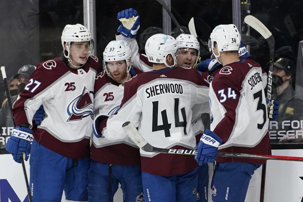 Colorado Avalanche players celebrate after defenseman Devon Toews scores goal.