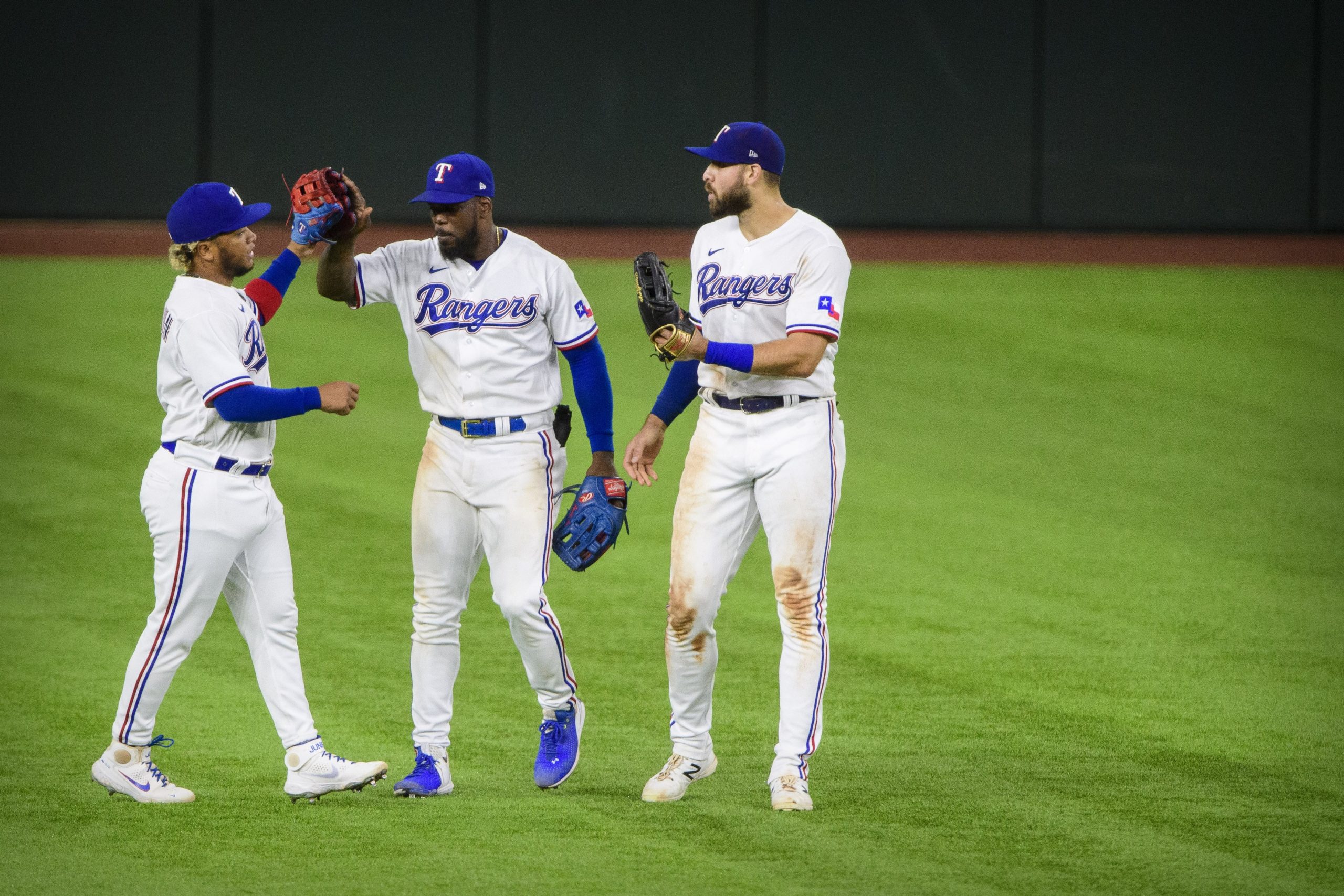 Texas Rangers left fielder Willie Calhoun (5) and center fielder Adolis Garcia (53) and right fielder Joey Gallo (13) celebrate the win over the New York Yankees at Globe Life Field