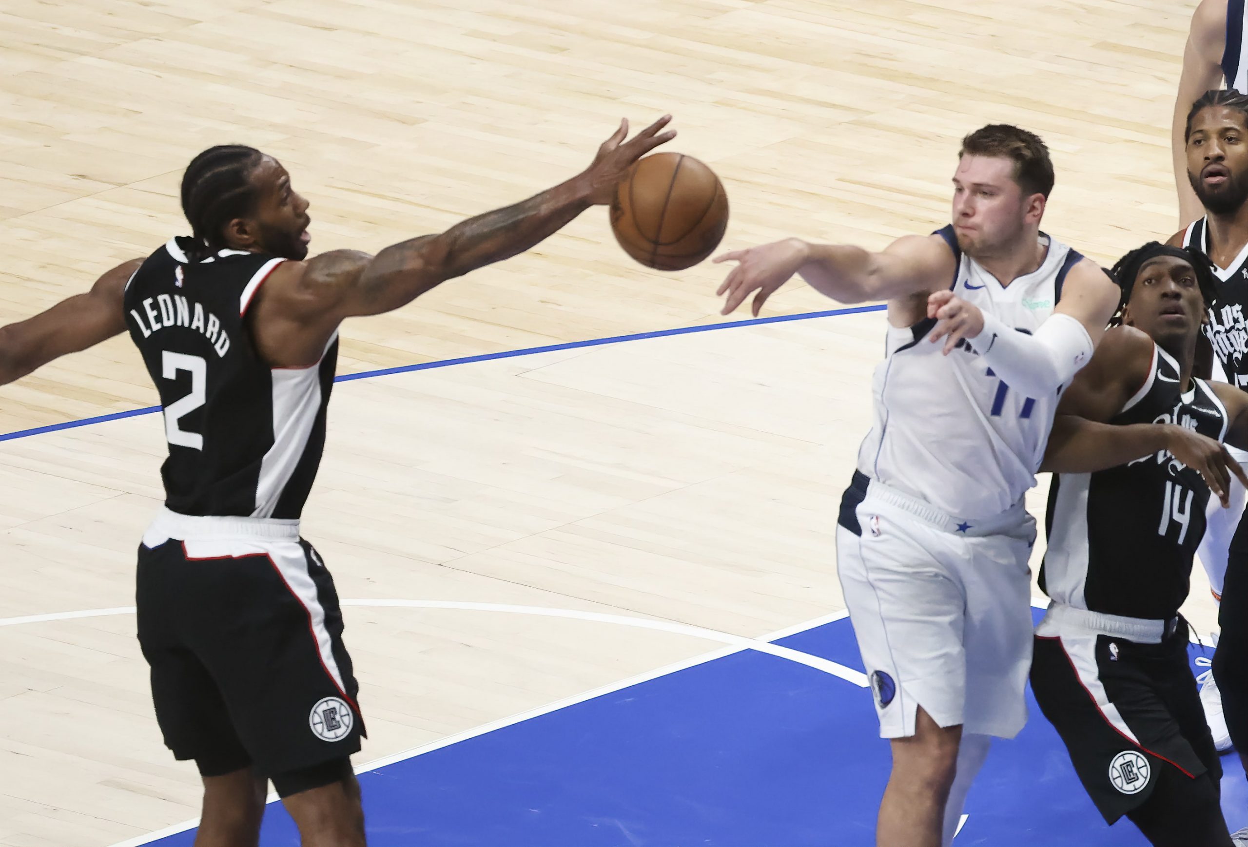 Dallas Mavericks guard Luka Doncic (77) passes around LA Clippers forward Kawhi Leonard (2) during the second quarter in game four in the first round of the 2021 NBA Playoffs at American Airlines Center.