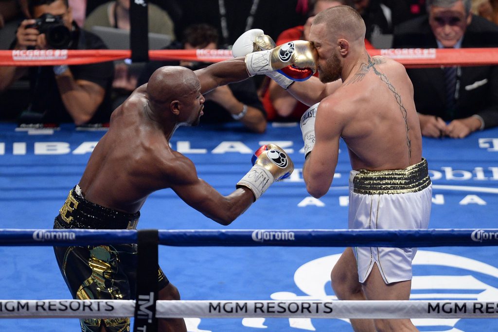 Conor McGregor (left) punches Floyd Mayweather Jr. during a boxing match at T-Mobile Arena.