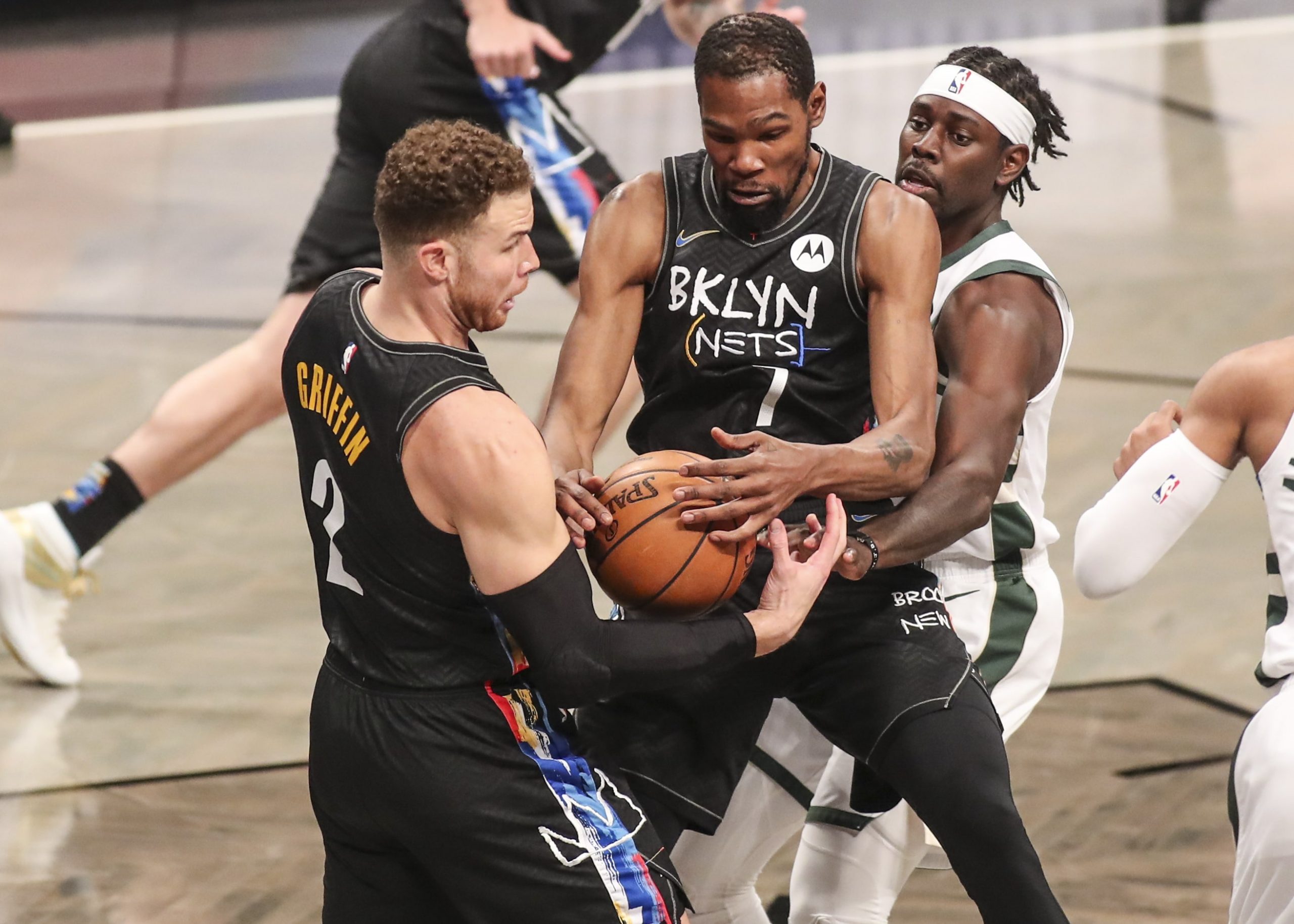 Brooklyn Nets forwards Kevin Durant (7) and Blake Griffin (2) and Milwaukee Bucks guard Jrue Holiday (21) try to grab a loose ball in the first quarter during game two in the second round of the 2021 NBA Playoffs.
