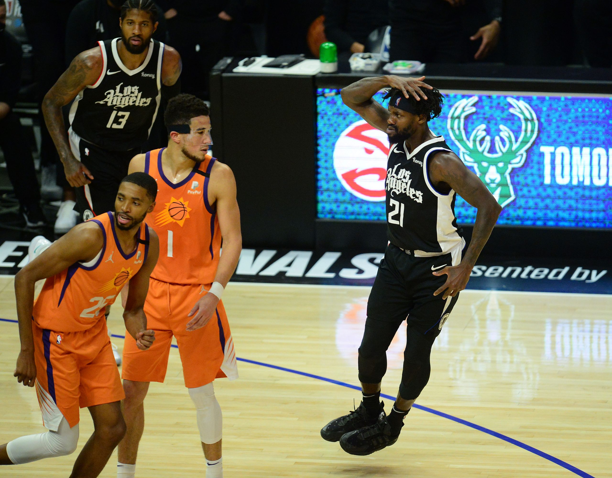 Los Angeles Clippers guard Patrick Beverley (21) celebrates his basket scored in front of Phoenix Suns guard Devin Booker (1) and forward Mikal Bridges (25)