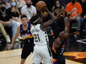 Milwaukee Bucks guard Jrue Holiday (21) shoots against Phoenix Suns guard Chris Paul (3) during the first half in game one of the 2021 NBA Finals at Phoenix Suns Arena