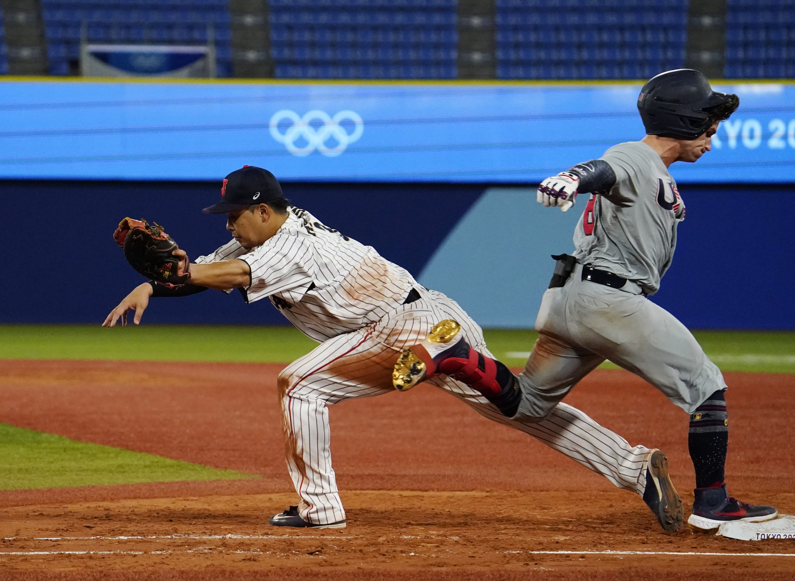 Olympic baseball Team United States catcher Mark Kolozsvary (8) beats the throw to Team Japan infielder Hideto Asamura (3) in a second round baseball game during the Tokyo 2020 Olympic Summer Games at Yokohama Baseball Stadium