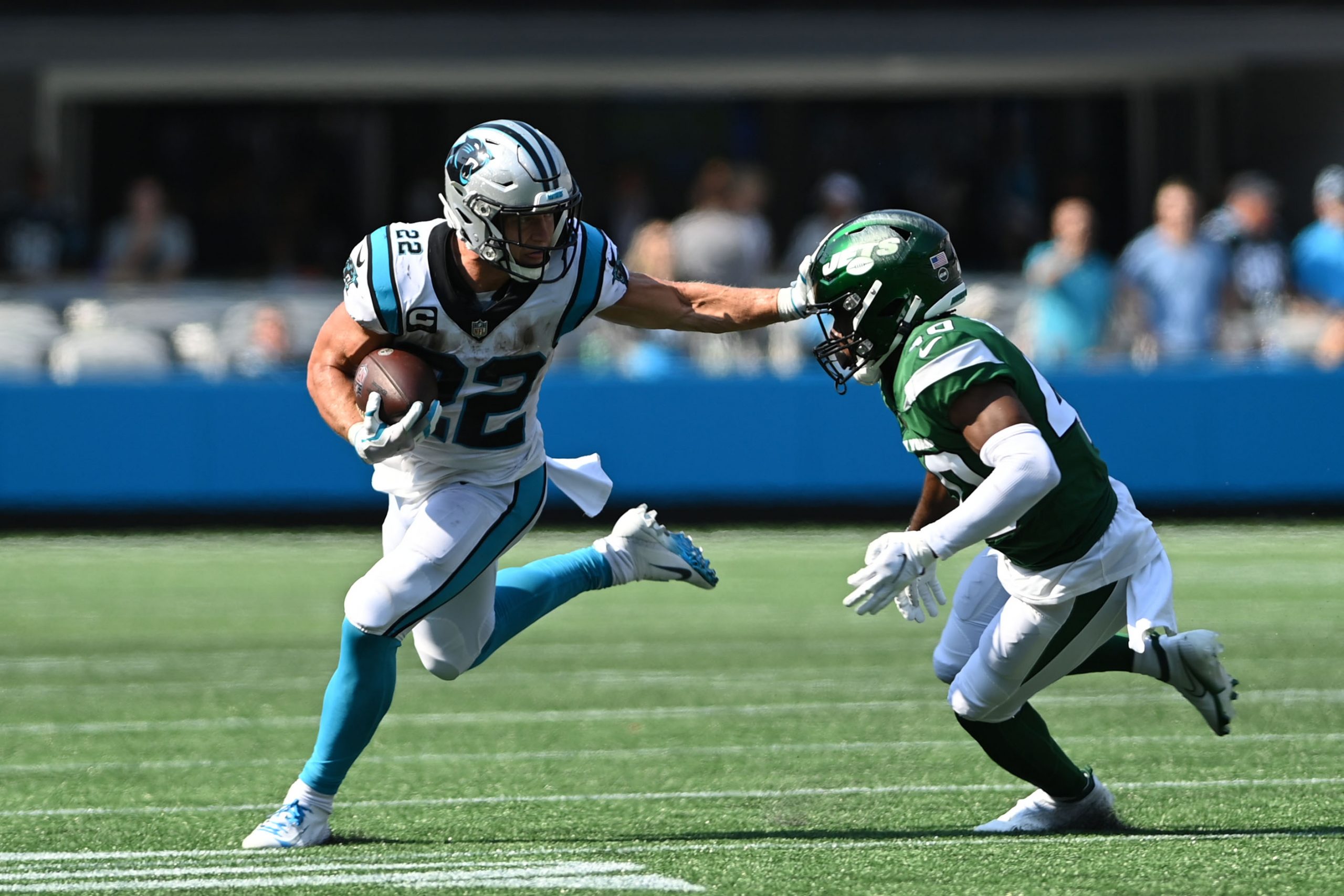 Sep 12, 2021; Charlotte, North Carolina, USA; Carolina Panthers running back Christian McCaffrey (22) with the ball as New York Jets cornerback Javelin Guidry (40) defends in the fourth quarter at Bank of America Stadium.