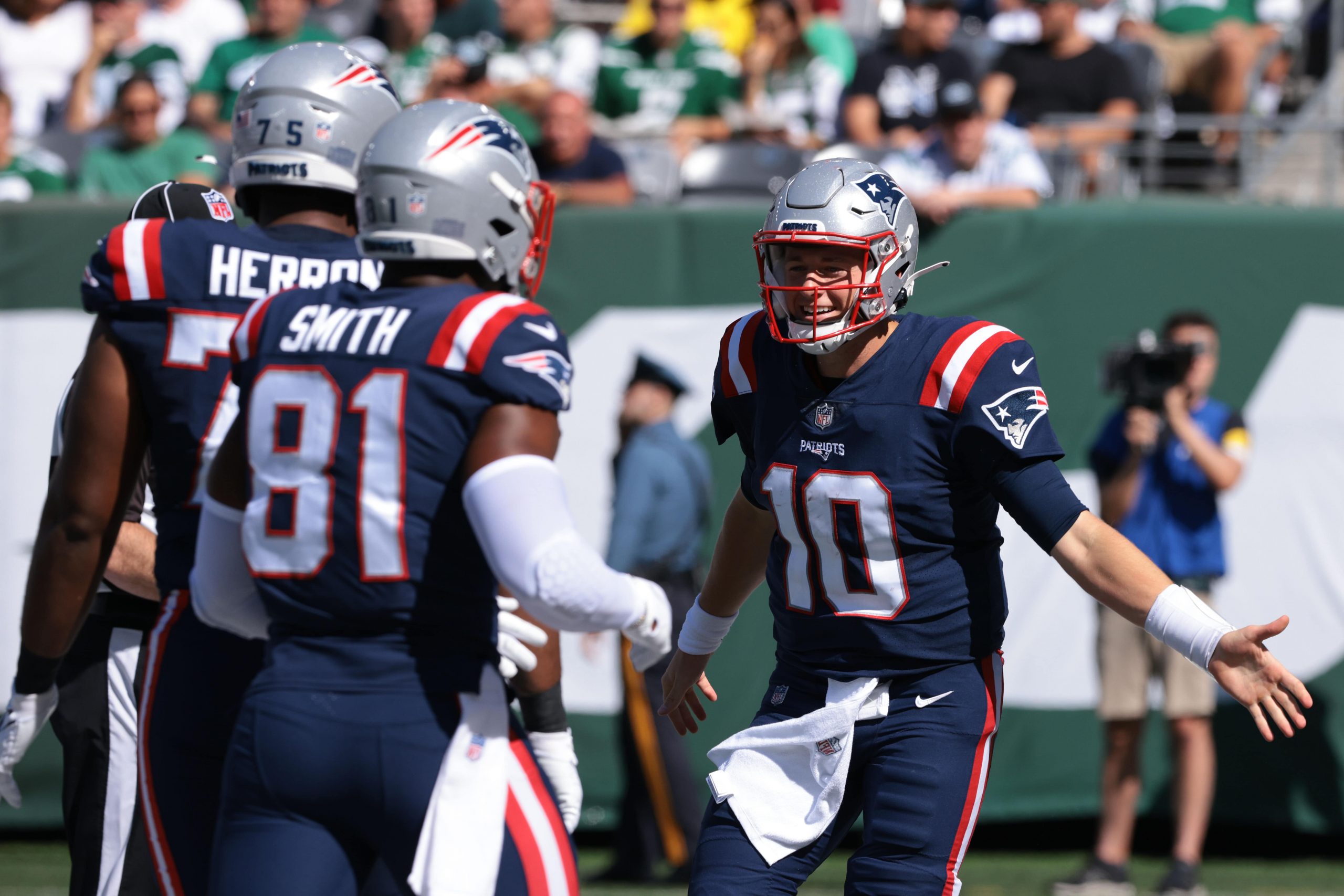 New England Patriots quarterback Mac Jones (10) celebrates with offensive guard Alijah Vera-Tucker (75) and tight end Jonnu Smith (81) after a Patriots touchdown during the second half against the New York Jets.