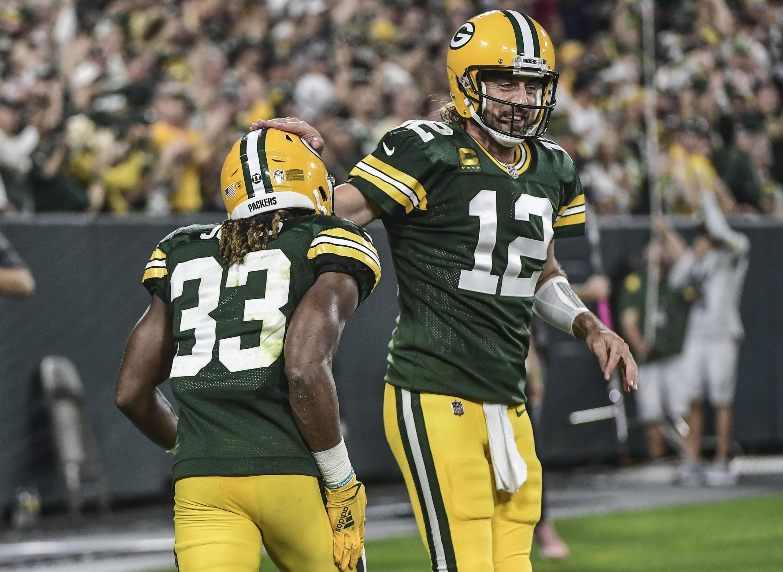 Green Bay Packers running back Aaron Jones (33) celebrates with quarterback Aaron Rodgers (12) after scoring a touchdown against the Detroit Lions in the first quarter at Lambeau Field