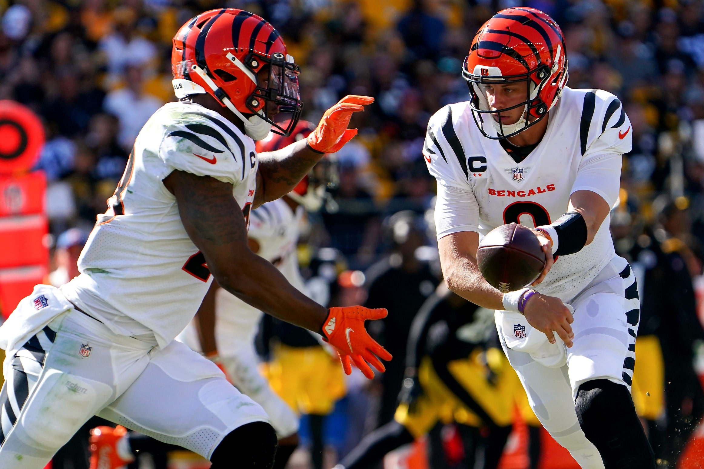 Cincinnati Bengals quarterback Joe Burrow (9) hands the ball off to Cincinnati Bengals running back Joe Mixon (28) in the third quarter during a Week 3 NFL football game, Sunday, Sept. 26, 2021
