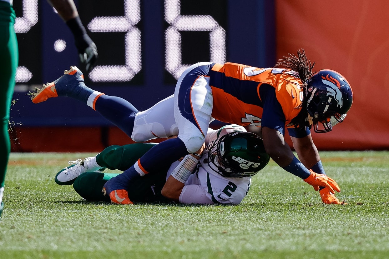 New York Jets quarterback Zach Wilson (2) is sacked by Denver Broncos linebacker Alexander Johnson (45) in the first quarter at Empower Field at Mile High.