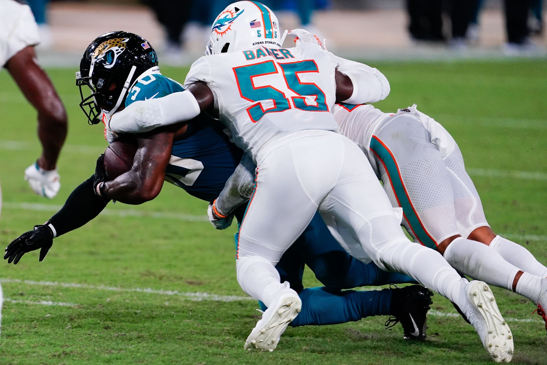 Jacksonville Jaguars running back James Robinson (30) runs with the ball against Miami Dolphins linebacker Jerome Baker (55) during the second half at TIAA Bank Field.