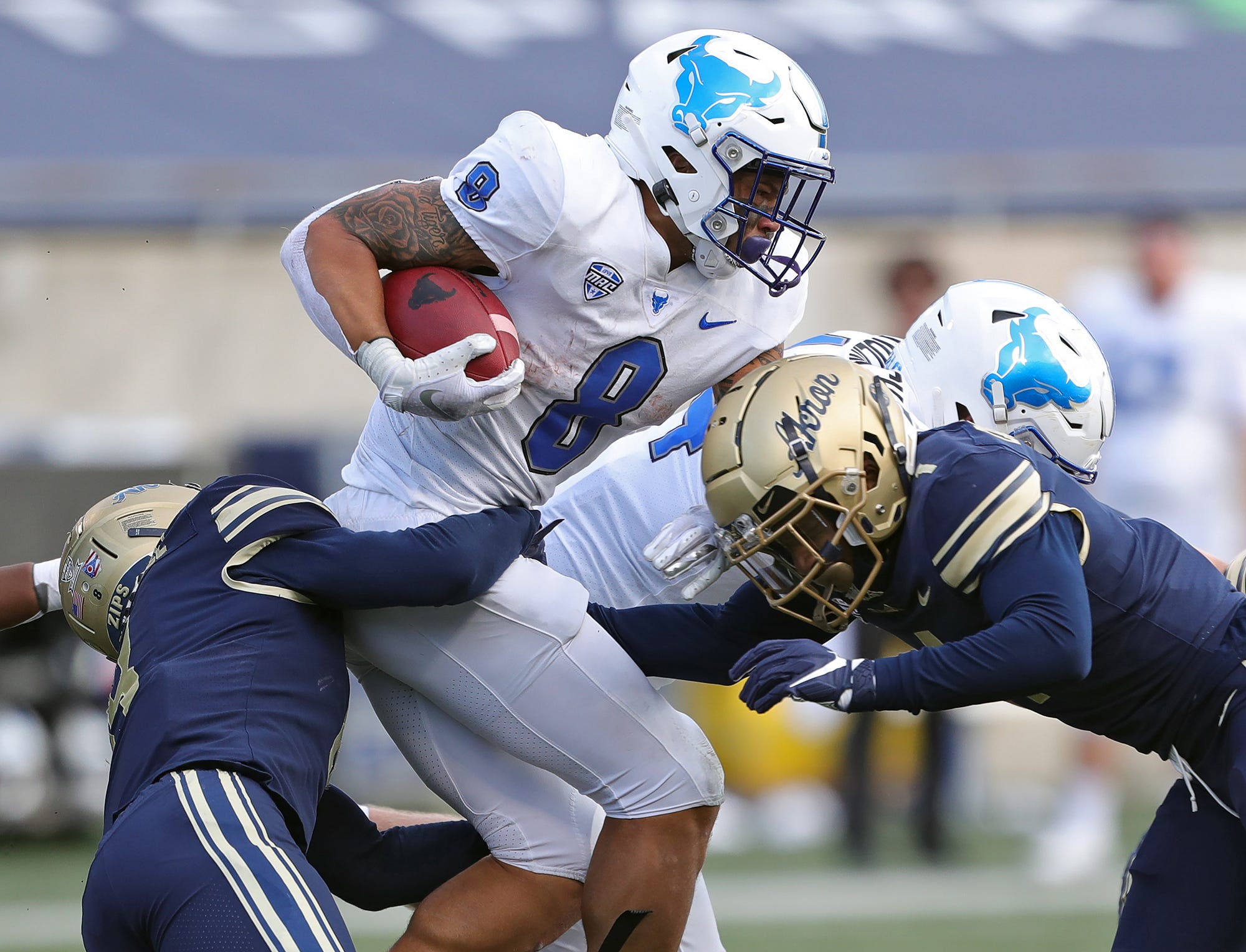 Buffalo Bulls running back Dylan McDuffie (8) is brought down by a host of Akron Zips players during the first half of an NCAA college football game, Saturday, Oct. 23, 2021, in Akron, Ohio