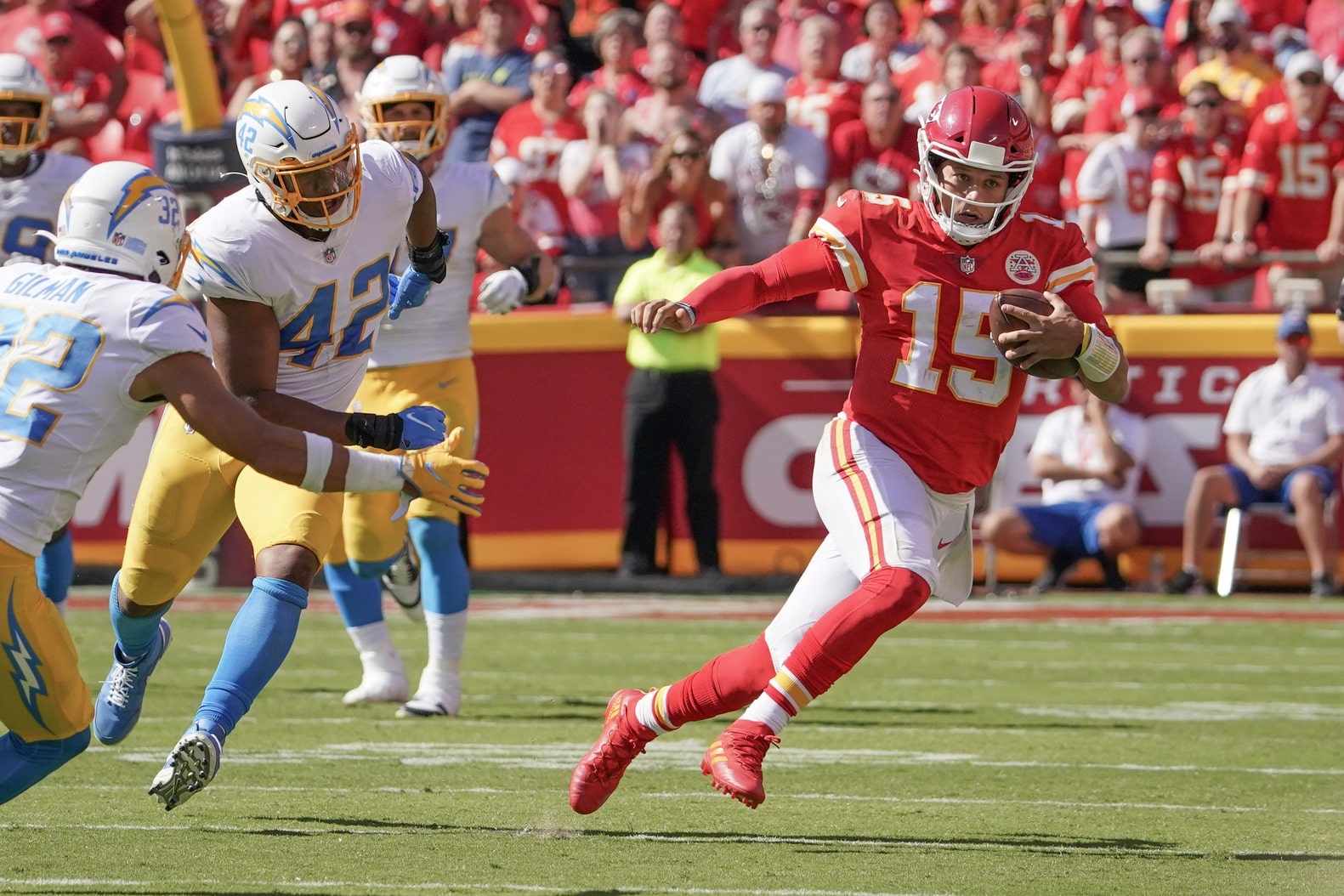 Kansas City Chiefs quarterback Patrick Mahomes (15) runs the ball as Los Angeles Chargers safety Alohi Gilman (32) defends during the game at GEHA Field at Arrowhead Stadium.