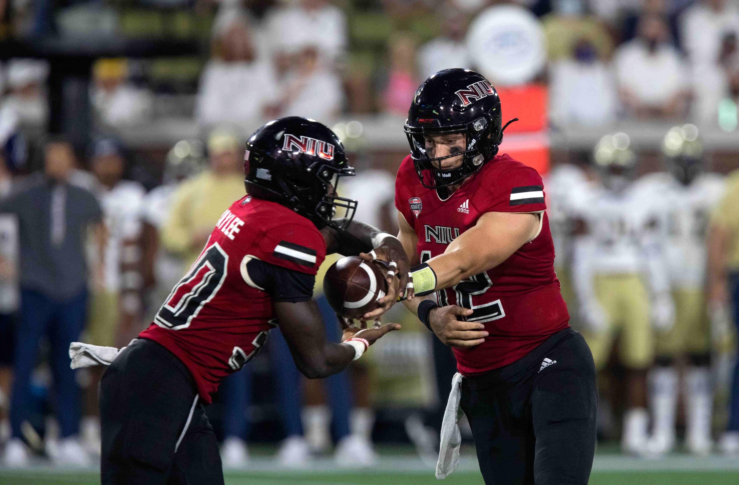 Northern Illinois Huskies quarterback Rocky Lombardi (12) hands off the ball to running back Harrison Waylee