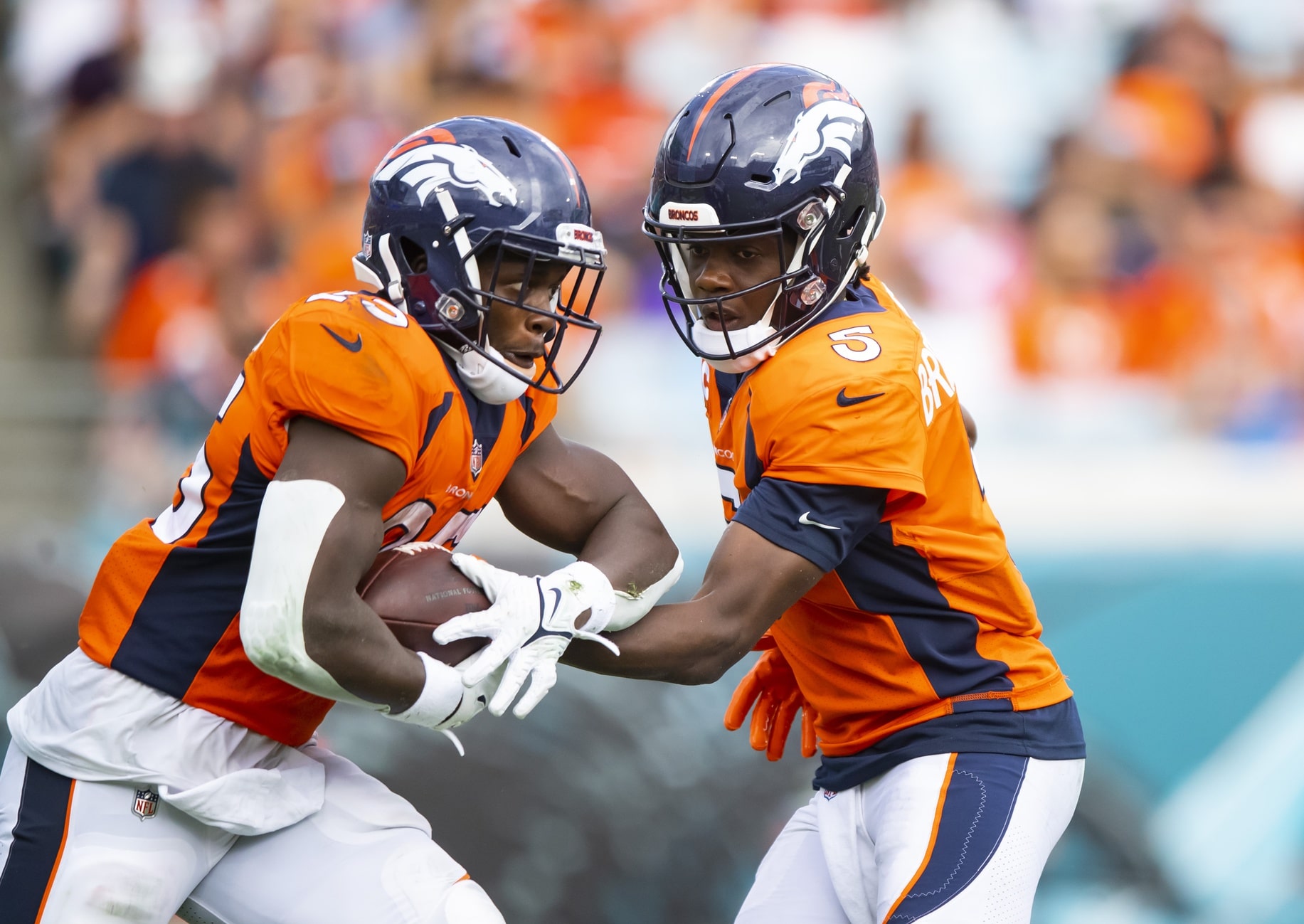 Denver Broncos quarterback Teddy Bridgewater (5) hands off the ball to running back Melvin Gordon III (25) against the Jacksonville Jaguars at TIAA Bank Field.