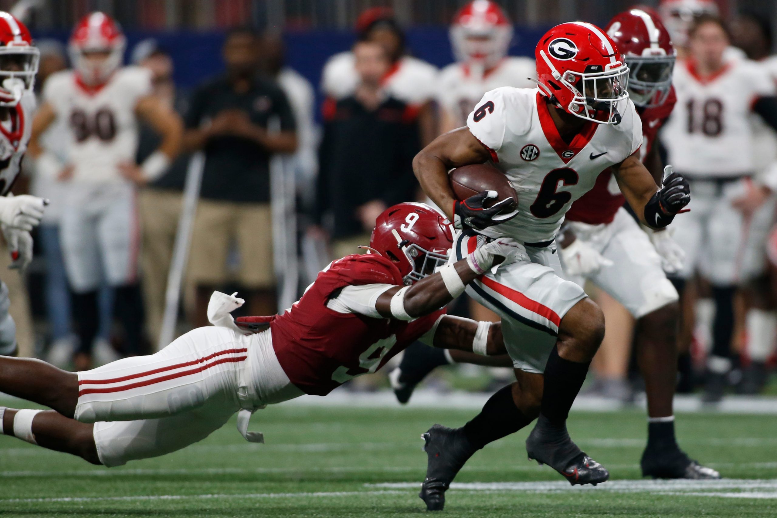 Georgia running back Kenny McIntosh (6) breaks away from Alabama defensive back Jordan Battle (9) during the second half of the Southeastern Conference championship NCAA college football game between Georgia and Alabama in Atlanta, on Saturday, Dec. 4, 2021