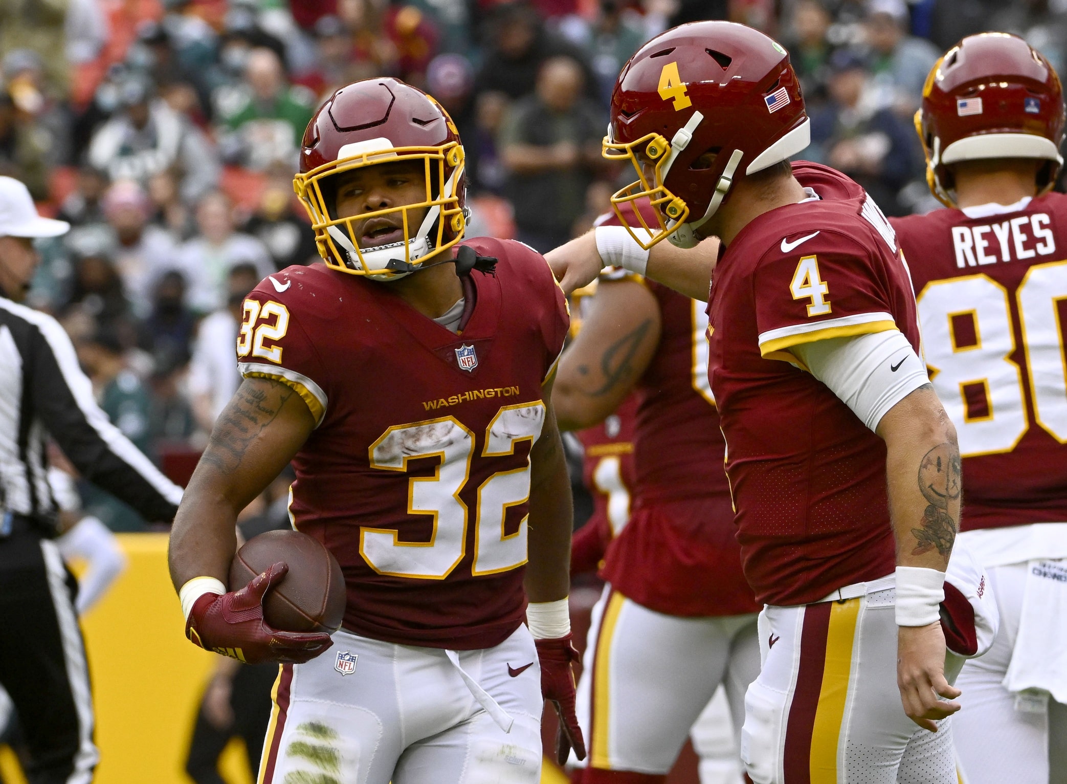 Washington Football Team running back Jaret Patterson (32) is congratulated by quarterback Taylor Heinicke (4) after scoring a touchdown against the Philadelphia Eagles during the first half at FedExField.