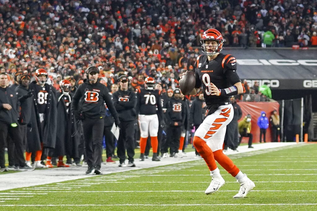 Cincinnati Bengals quarterback Joe Burrow (9) prepares to throw a touchdown pass to wide receiver Tyler Boyd during the first half of an NFL wild-card playoff football game, Saturday, Jan. 15, 2022, in Cincinnati.