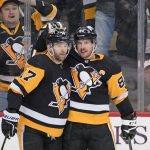 Pittsburgh Penguins' Sidney Crosby (87) celebrates his goal against the Ottawa Senators with Bryan Rust during the second period of an NHL hockey game in Pittsburgh, Thursday, Jan. 20, 2022