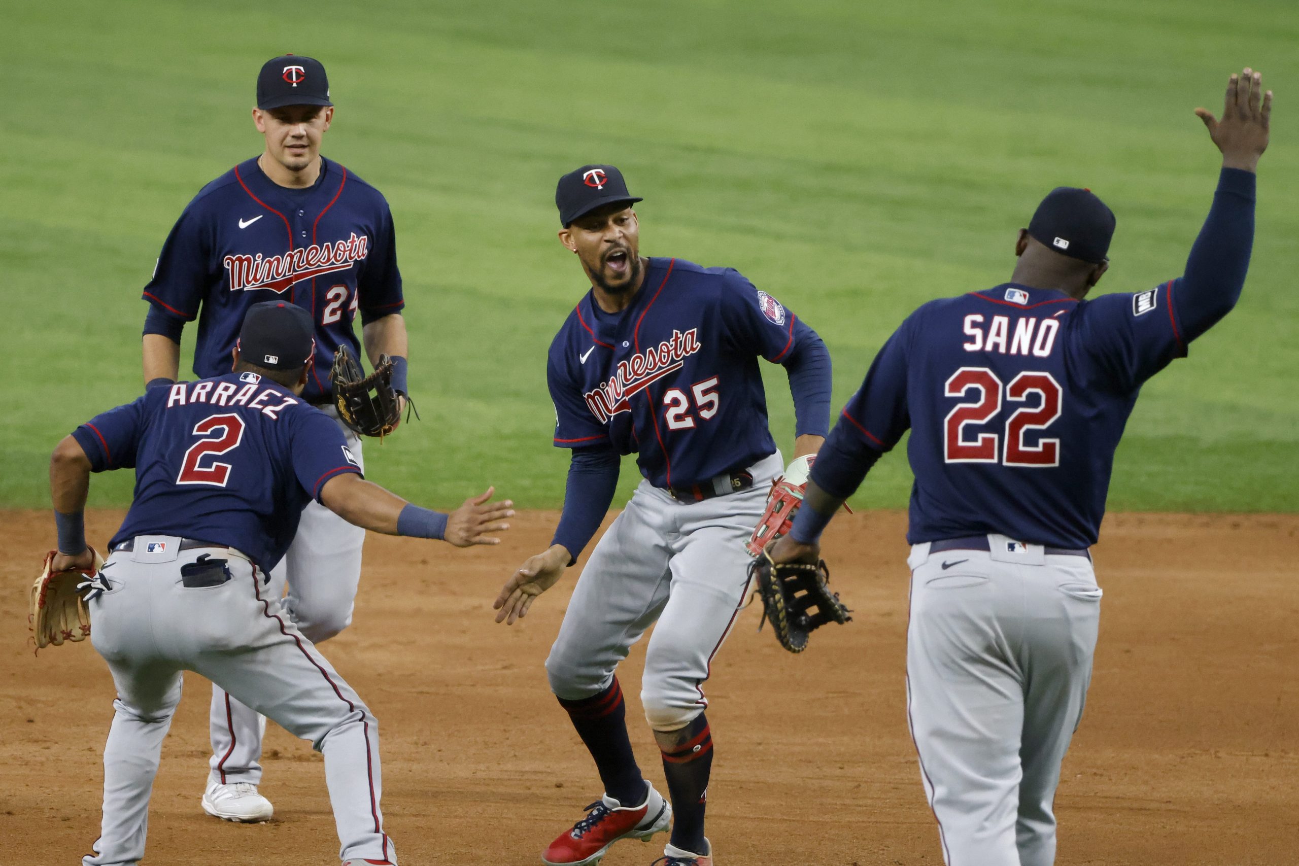 Minnesota Twins players Luis Arraez (2) Trevor Larnach (24), Byron Buxton (25) and Miguel Sano (22) celebrate their victory over the Texas Rangers in a baseball game Saturday, June 19, 2021, in Arlington, Texas.