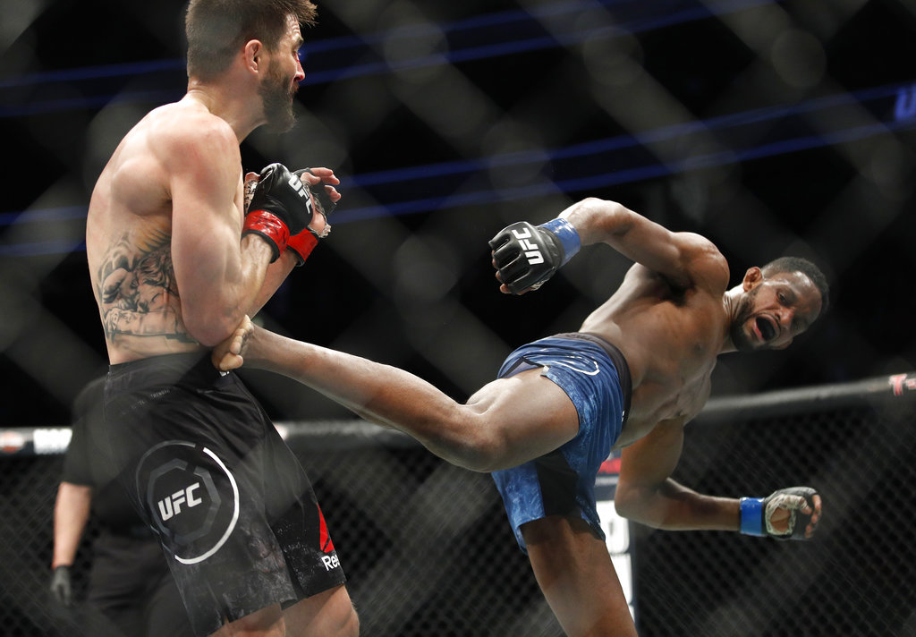 Neil Magny kicks Carlos Condit in a welterweight mixed martial arts bout at UFC 219, Saturday, Dec. 30, 2017, in Las Vegas.