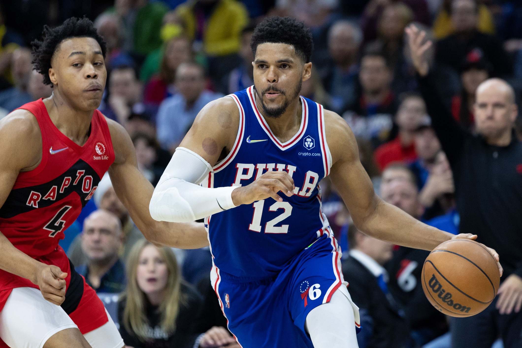 Philadelphia 76ers forward Tobias Harris (12) dribbles the ball past Toronto Raptors forward Scottie Barnes (4) during the third quarter in game five of the first round for the 2022 NBA playoffs at Wells Fargo Center.