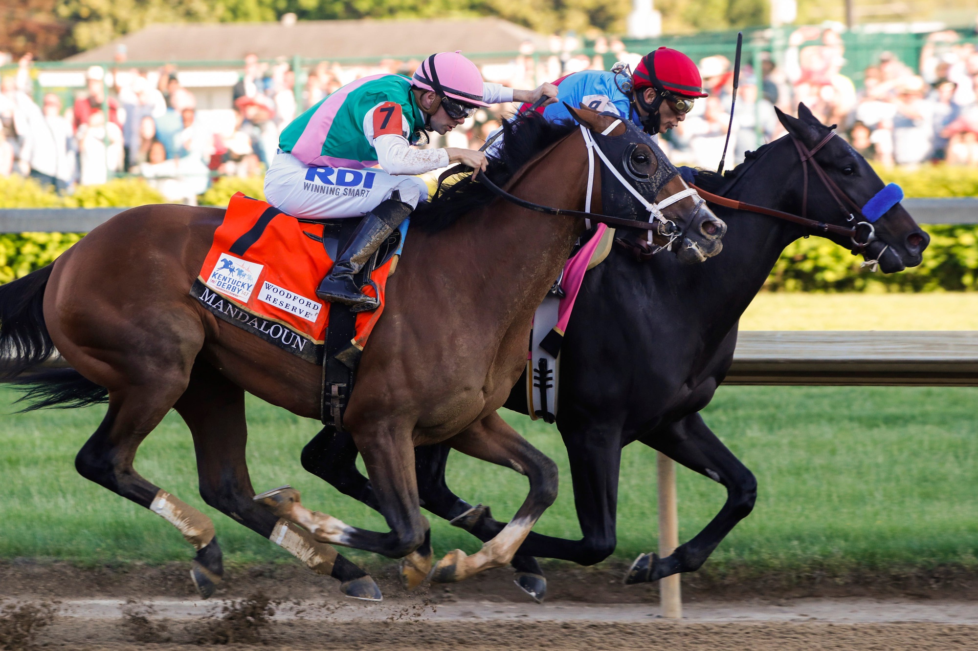 Medina Spirit and jockey John Velazquez, right, pull ahead of Mandaloun and jockey Florent Geroux in the final stretch in the Running of the 147th Kentucky Derby at Churchill Downs.