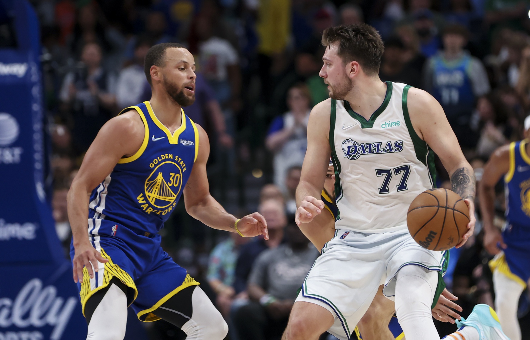Dallas Mavericks guard Luka Doncic (77) dribbles as Golden State Warriors guard Stephen Curry (30) defends during the game at American Airlines Center.